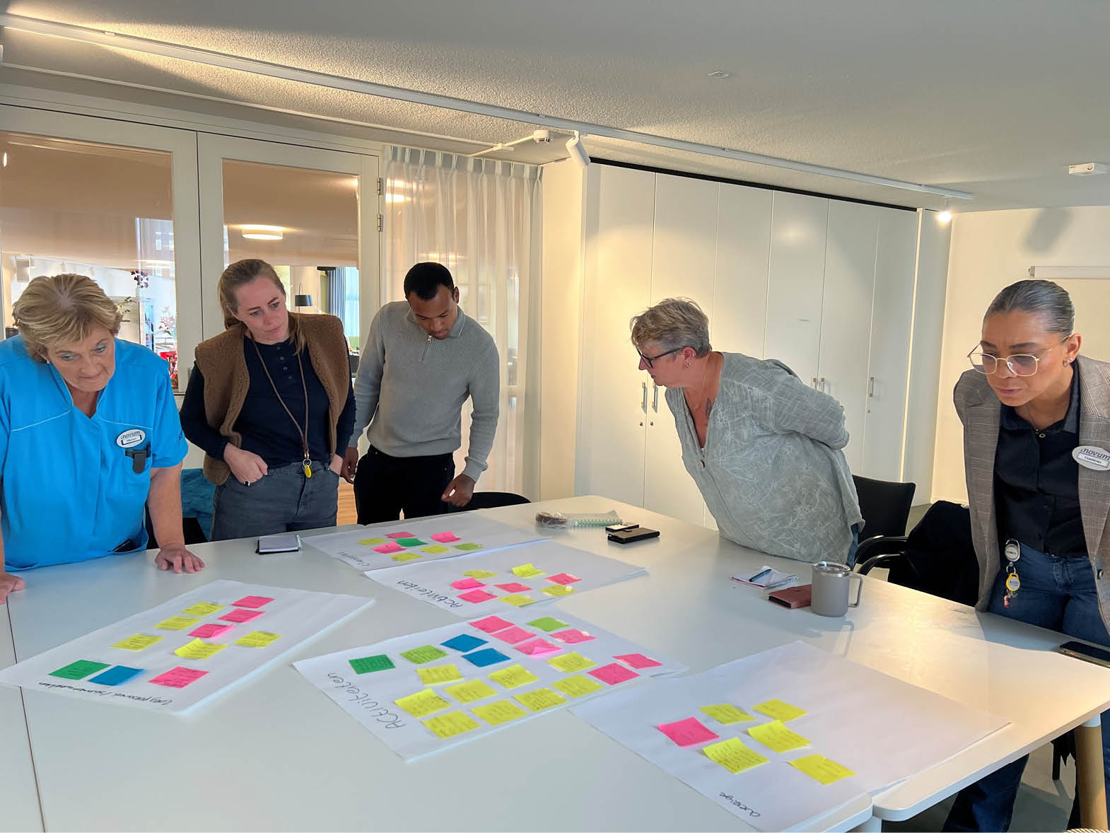 A group of people are gathered around a table with papers and sticky notes. AI generated content