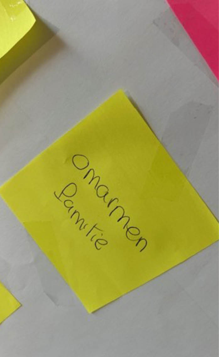 A yellow sticky note with black writing on a white surface. AI generated content